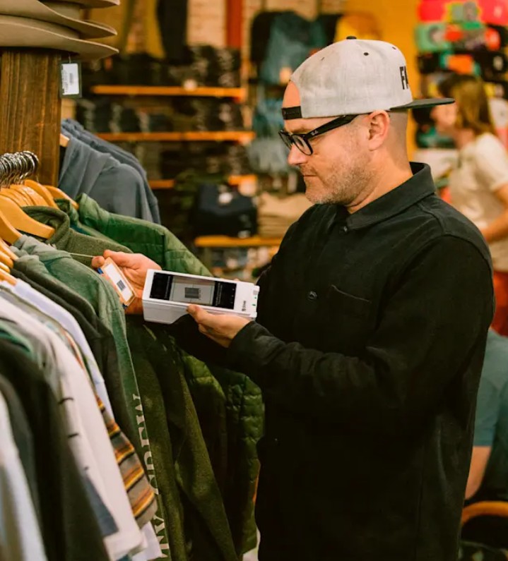 Personal de retail escaneando una etiqueta de precio con un Clover Flex