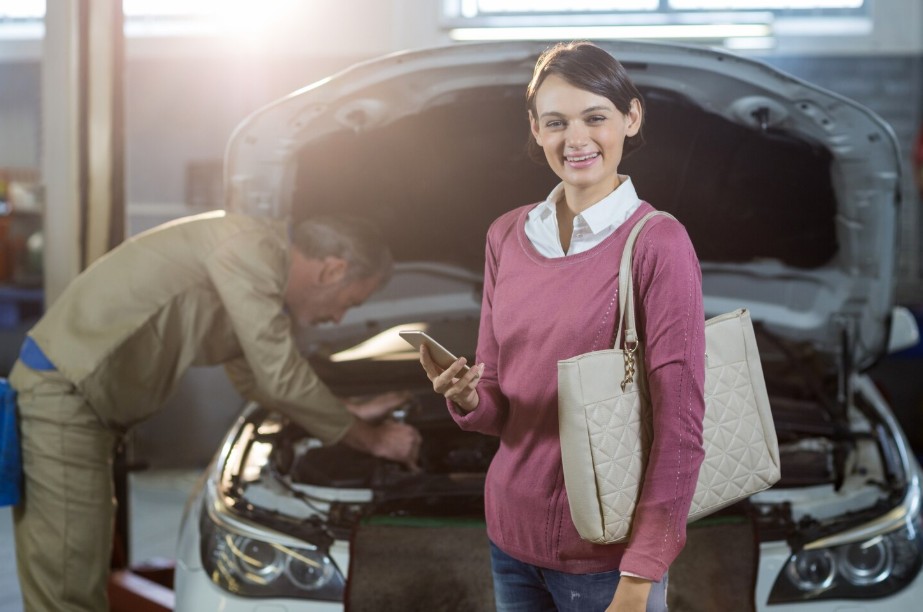 Auto service customer reviewing payment options on a phone at a repair shop
