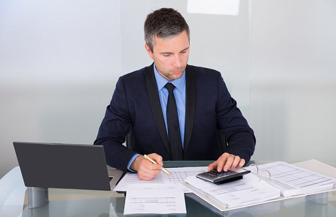 Professional reviewing invoices and payment documents at a desk