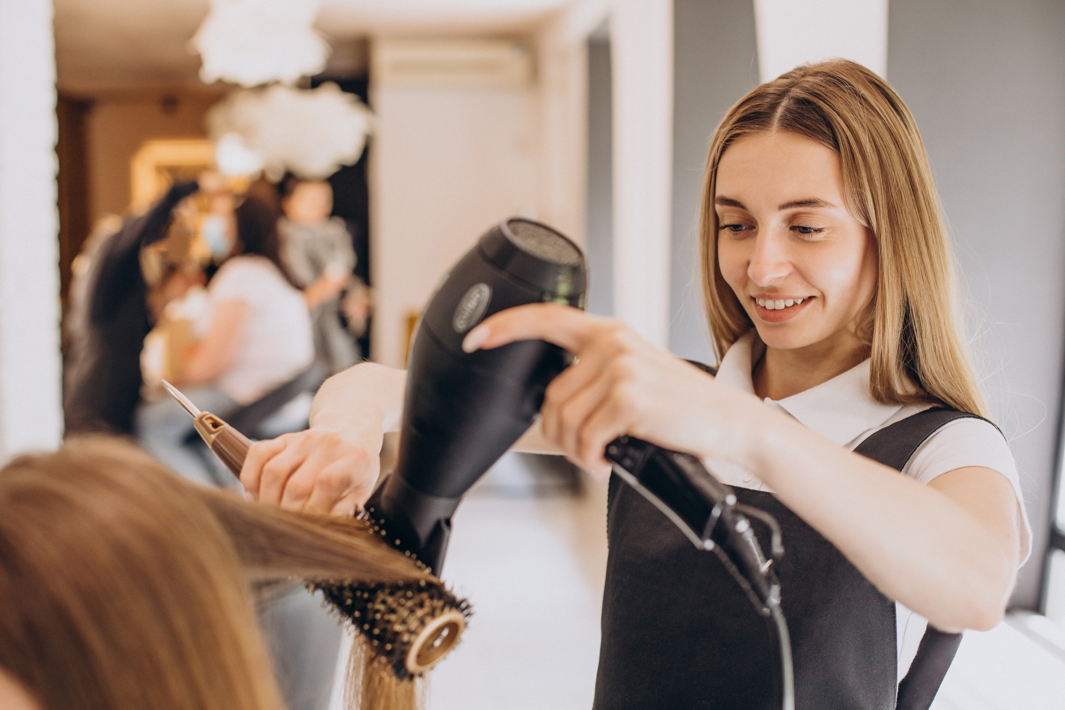 Estilista secando el cabello de un cliente en un salón