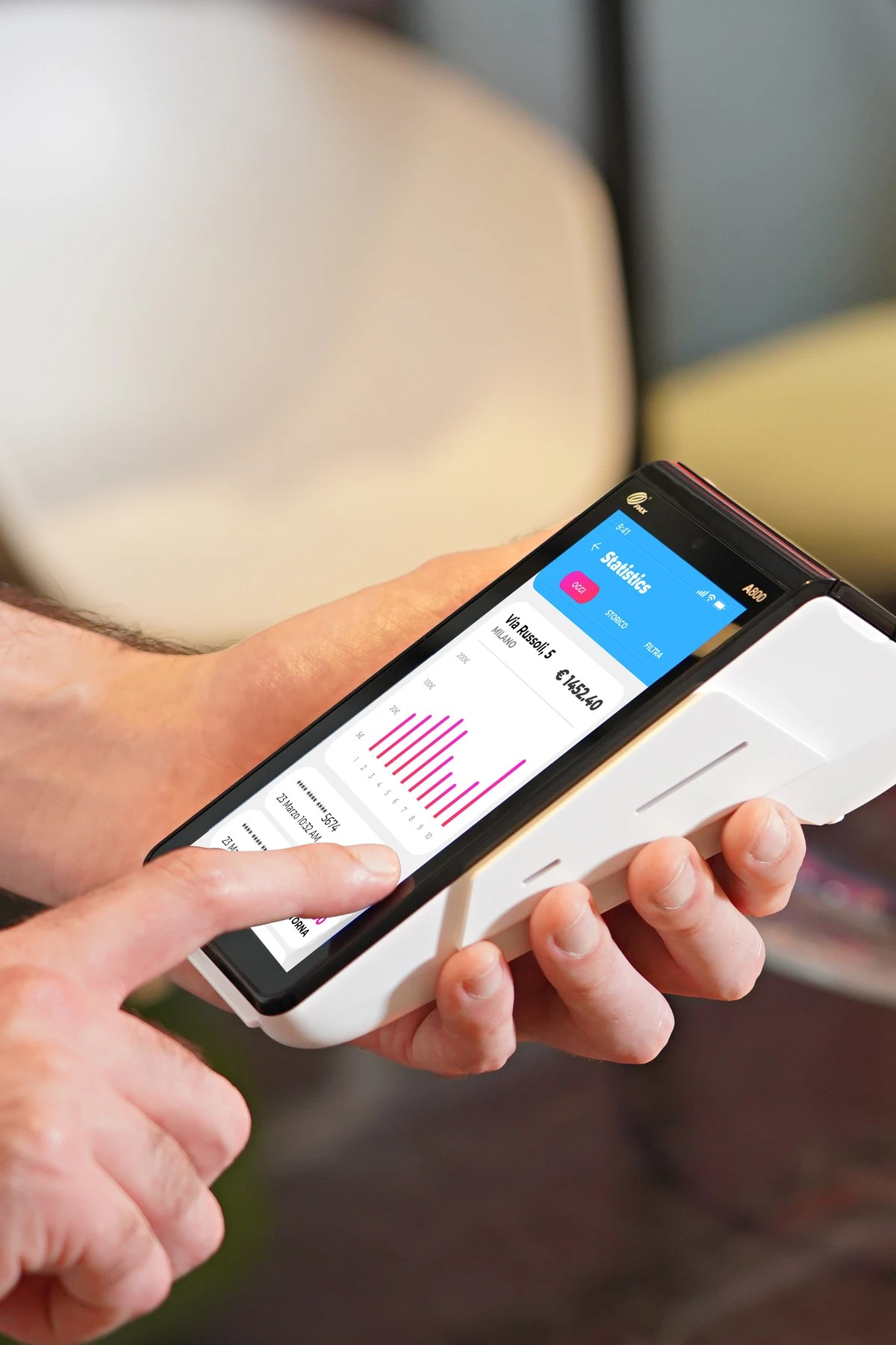 Staff member using a PAX handheld terminal for payment